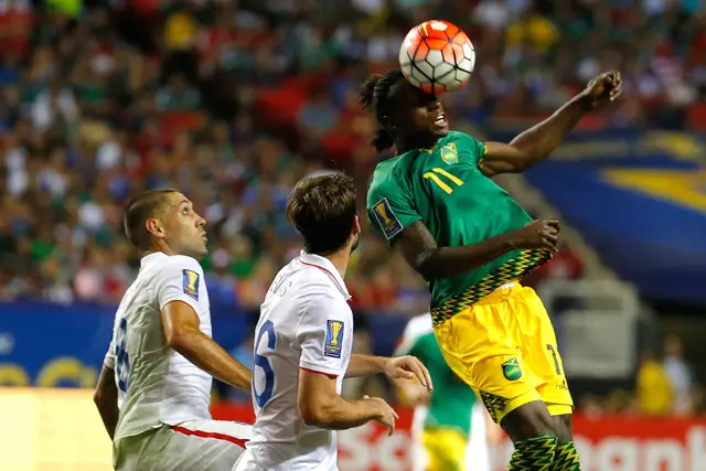 Darren Mattocks #11 of Jamaica wins a header against Clint Dempsey #8 and Brad Evans #16 of the United States of America